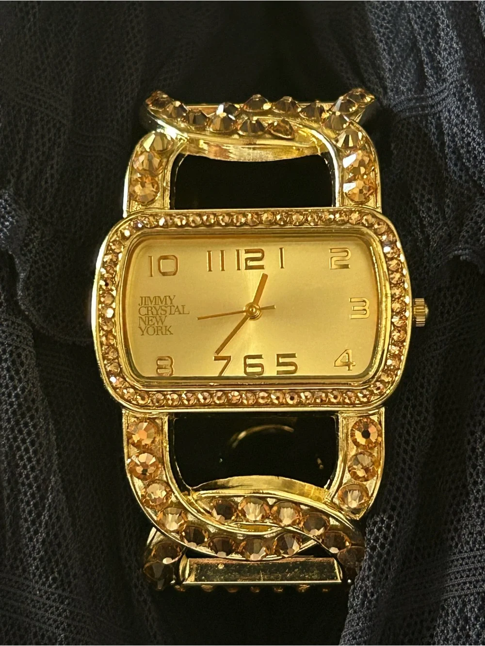 Jimmy Crystal elegant gold tone cuff watch with sparkling crystal accents.